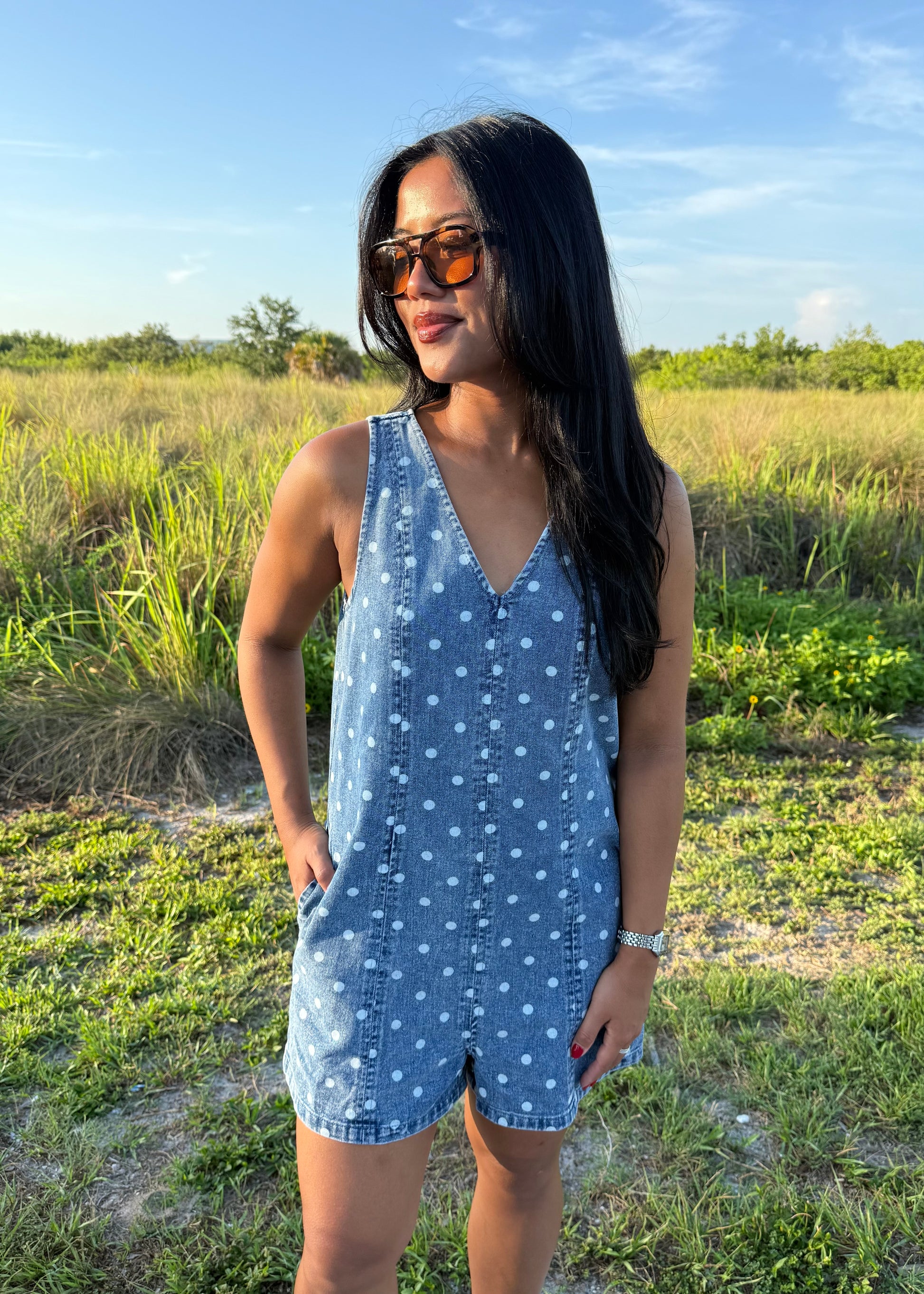 Girl wearing Millie Polka Dot Romper in Denim with grass background