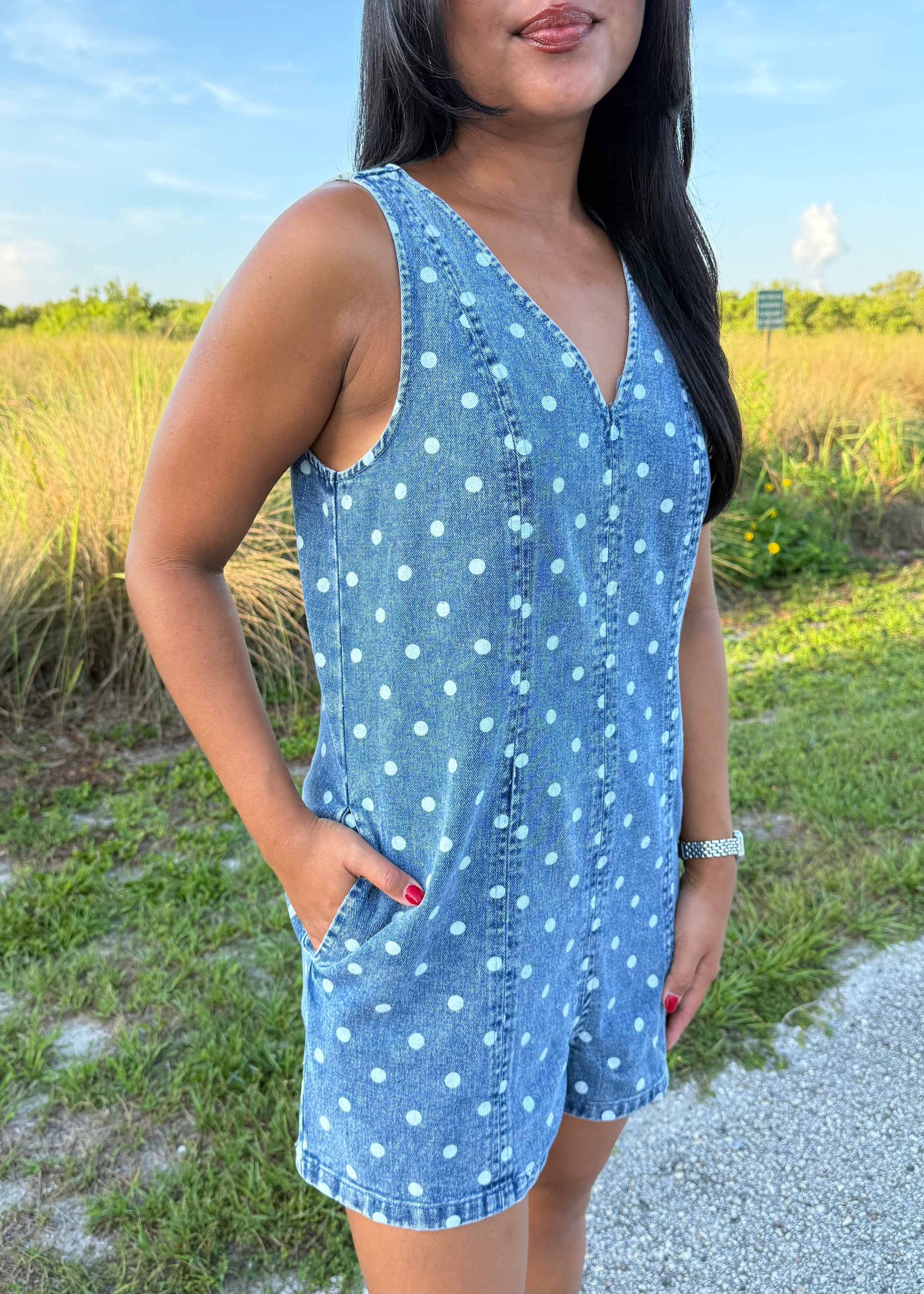 Girl wearing Millie Polka Dot Romper in Denim with grass background