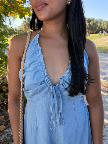 Woman wearing a light blue dress with a natural setting in the background