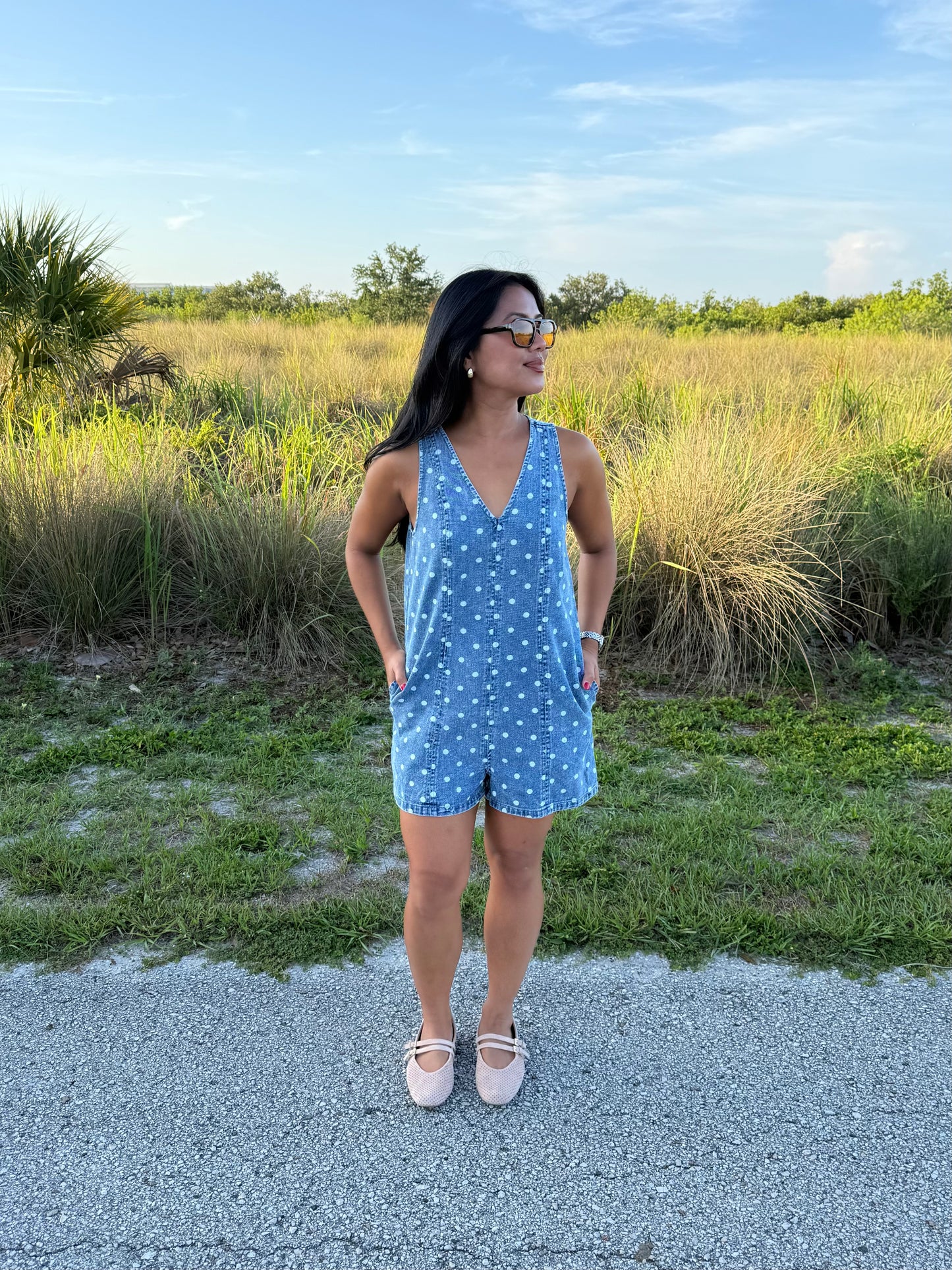 Girl wearing Millie Polka Dot Romper in Denim with grass background