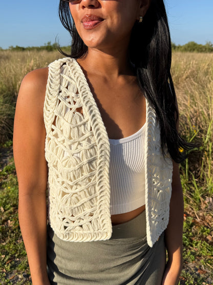 Woman wearing a white crochet vest in a field
