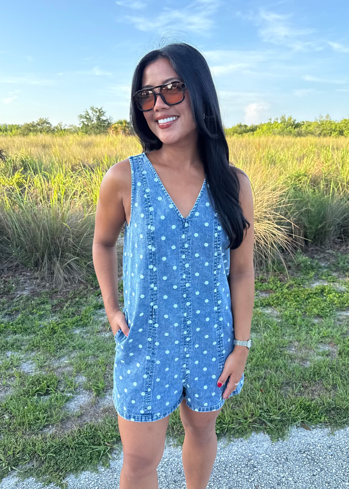 Girl wearing Millie Polka Dot Romper in Denim with grass background