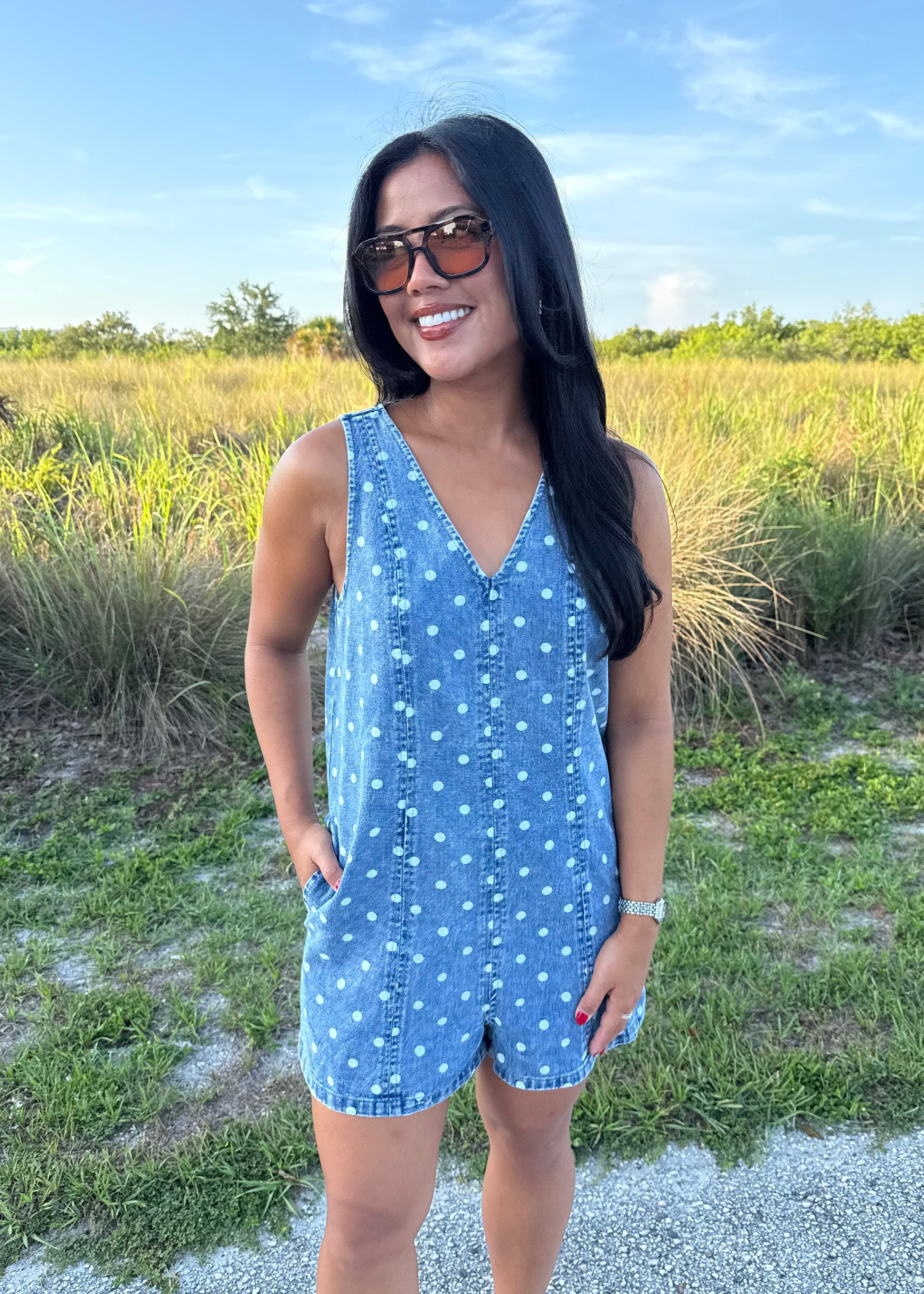 Girl wearing Millie Polka Dot Romper in Denim with grass background