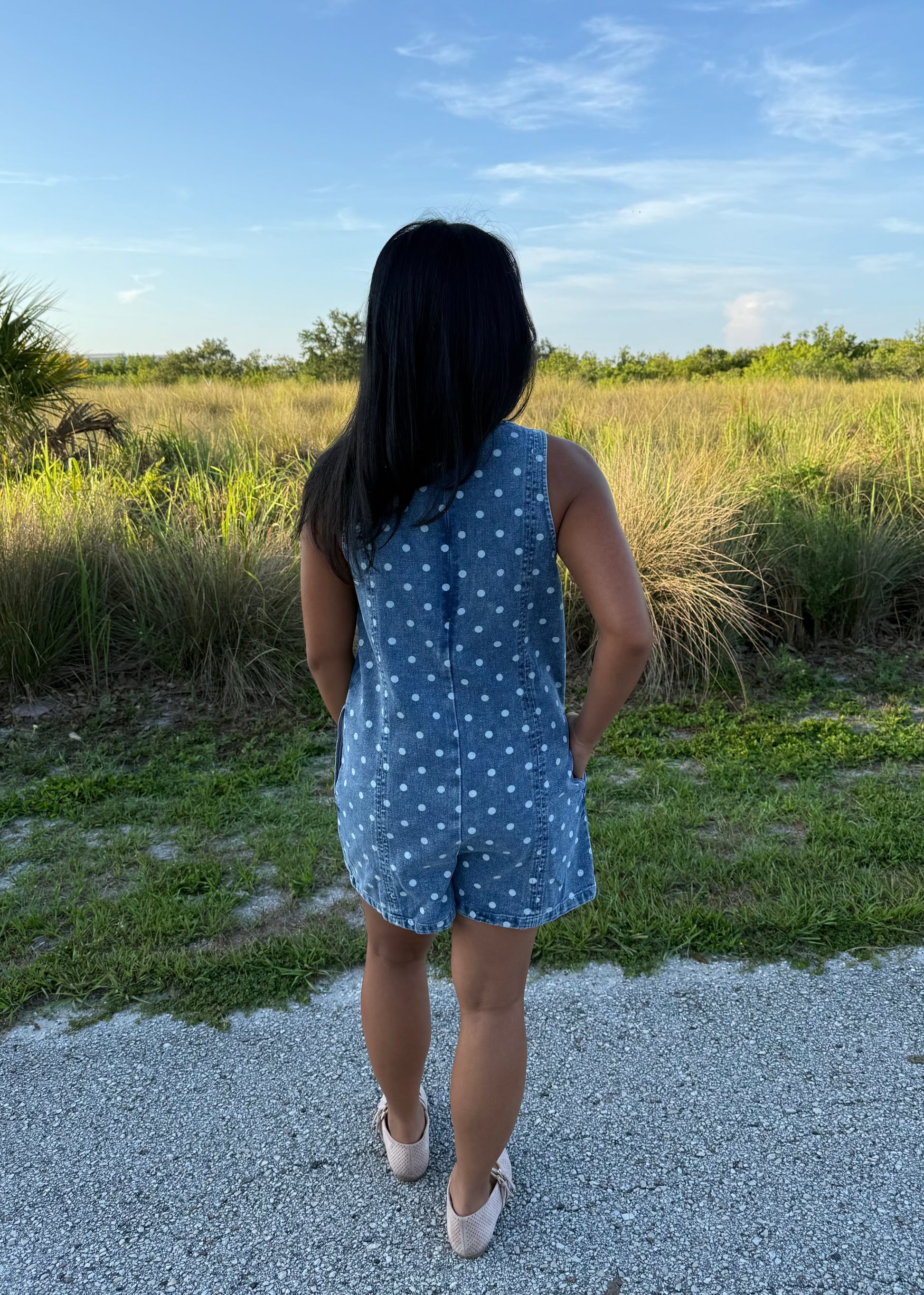 Girl wearing Millie Polka Dot Romper in Denim with grass background