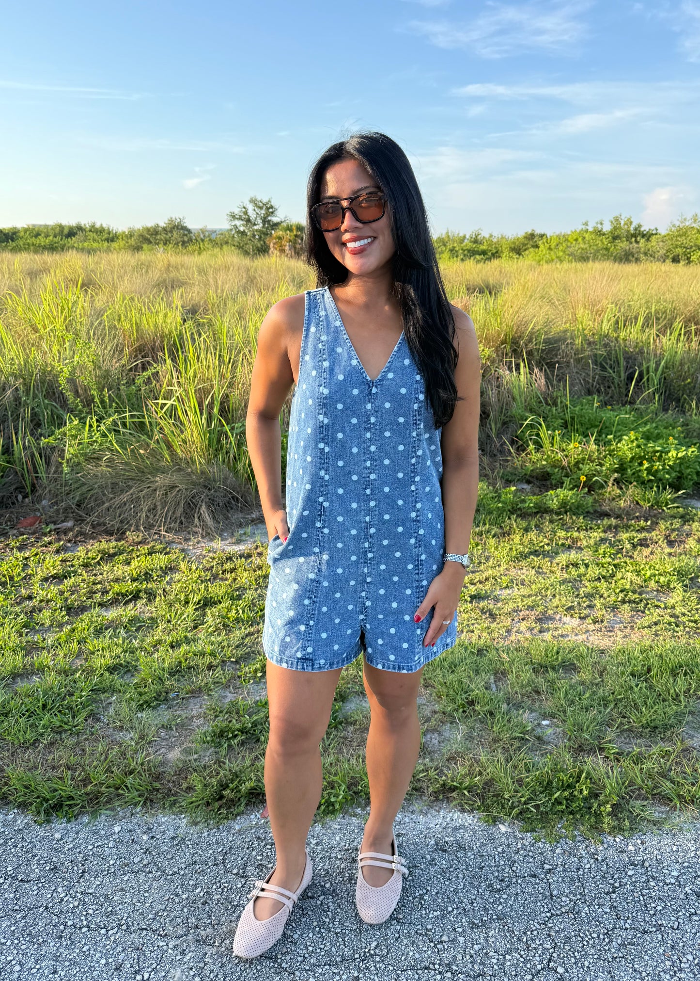 Girl wearing Millie Polka Dot Romper in Denim with grass background
