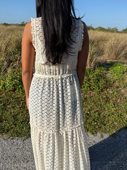 Person wearing a patterned dress standing in a natural setting with grass and sky.