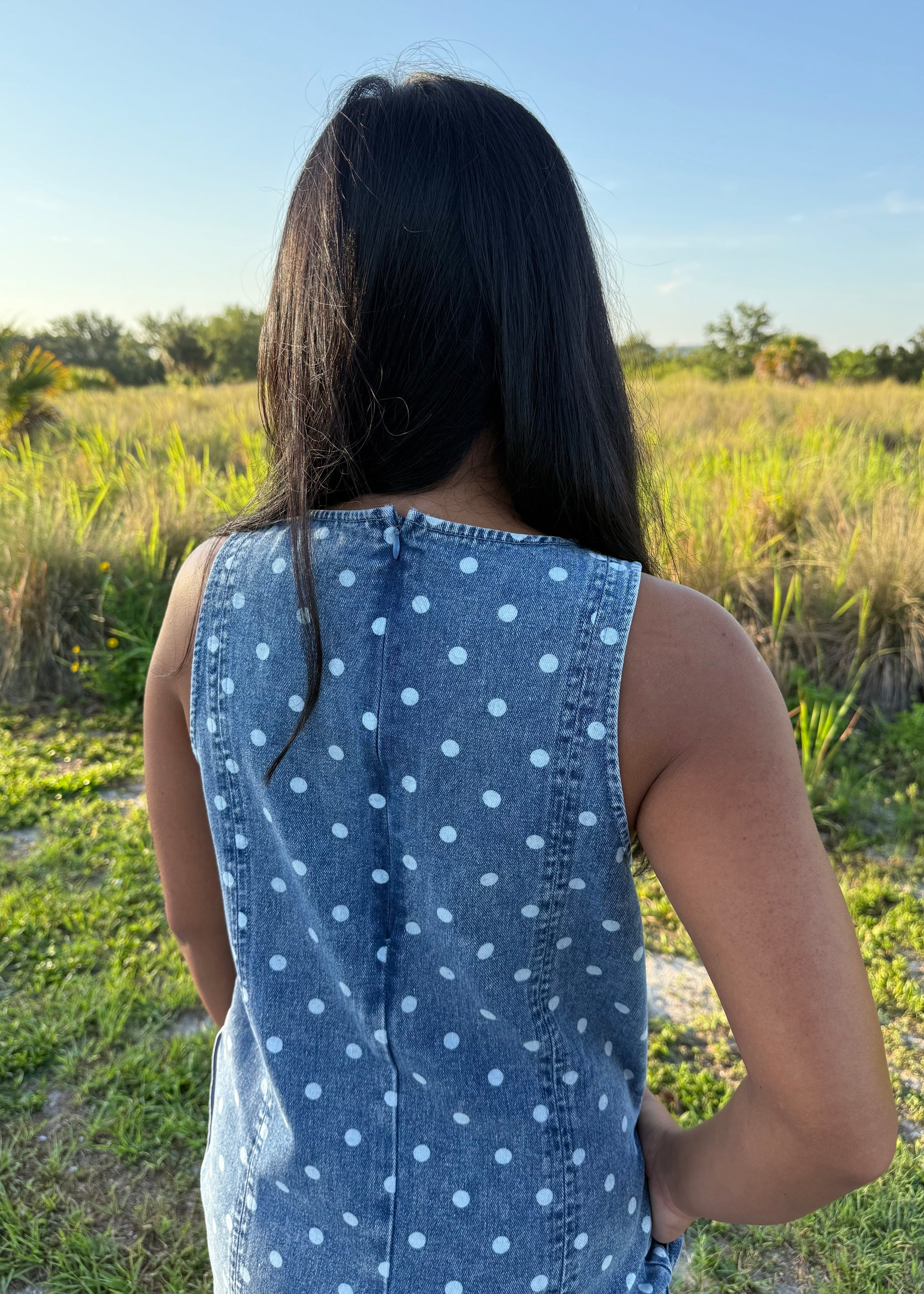 Girl wearing Millie Polka Dot Romper in Denim with grass background