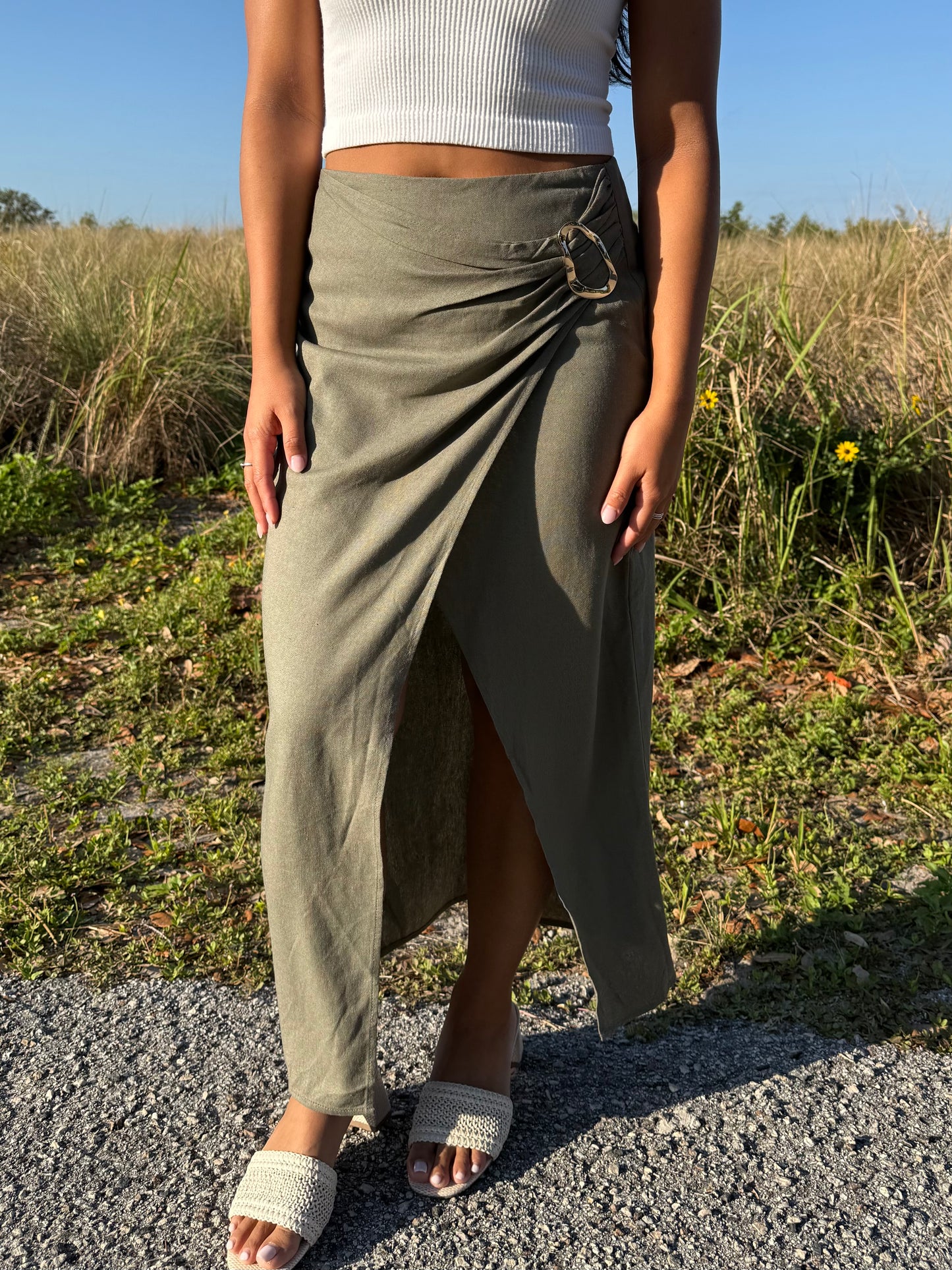 Person wearing a green skirt and white top outdoors