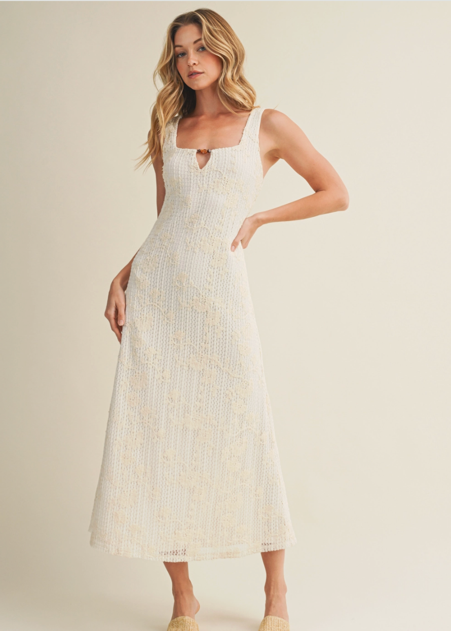 Woman wearing a white dress with a subtle pattern on a beige background