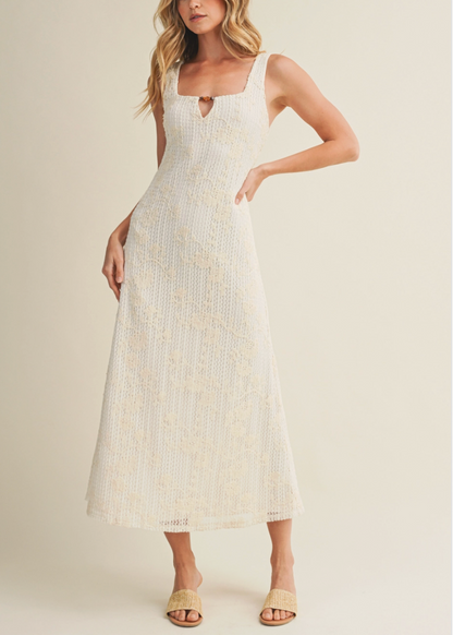 Woman wearing a white dress with a subtle pattern on a plain background