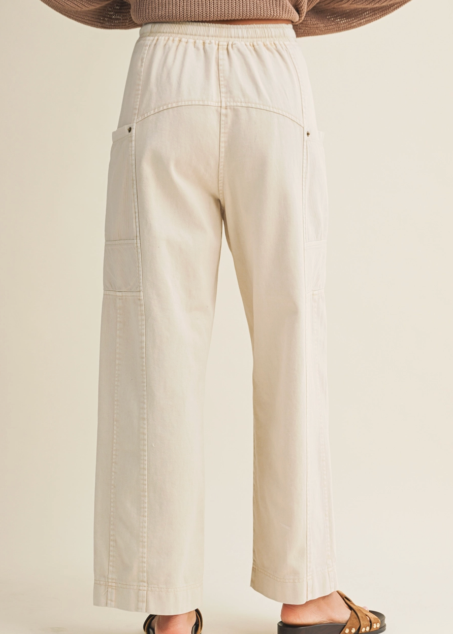 Beige wide-leg pants worn by a person on a beige background