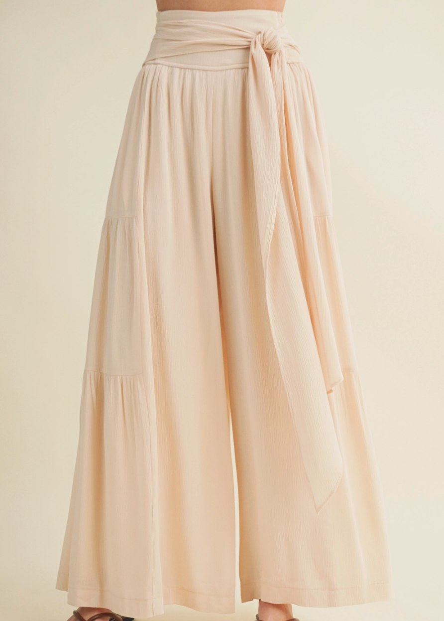 Beige wide-leg pants with a tie waist on a beige background
