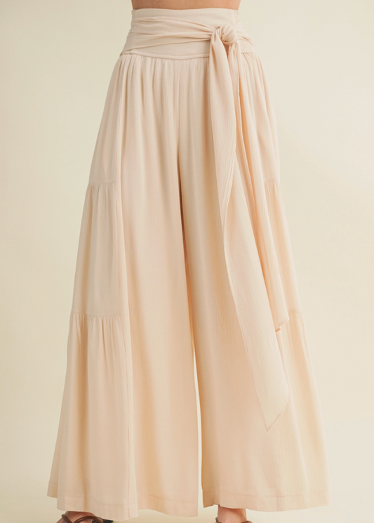 Beige wide-leg pants with a tie waist on a beige background