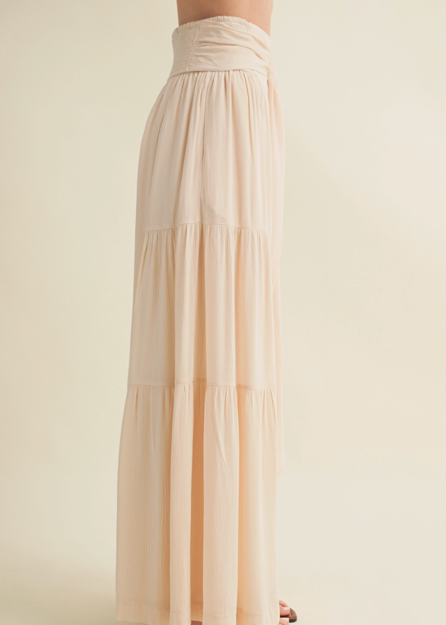 Beige tiered pants worn by a person on a plain background