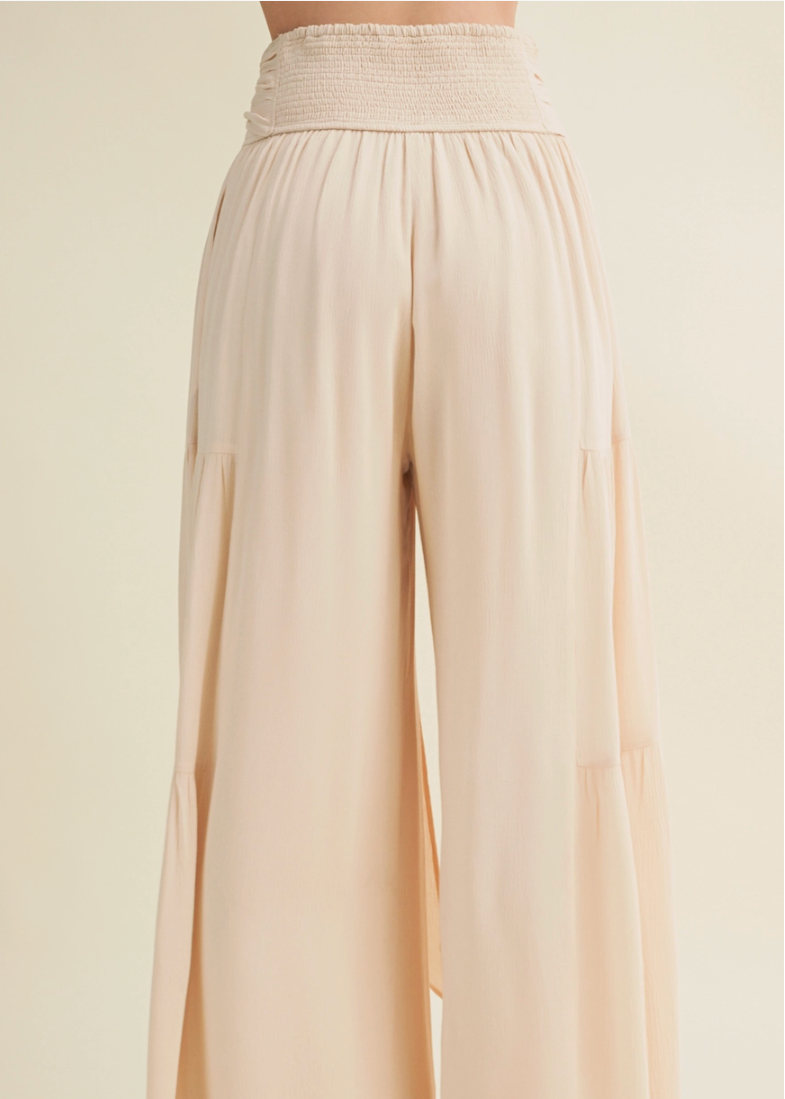 Beige wide-leg pants on a plain background