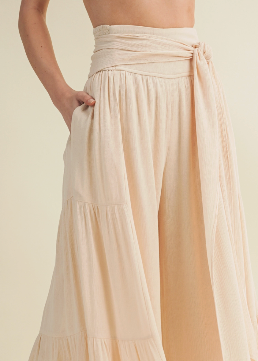 Beige flowy pants on a plain background