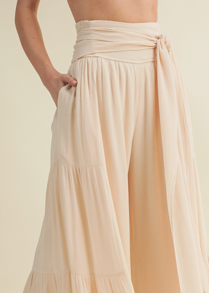 Beige flowy pants on a plain background