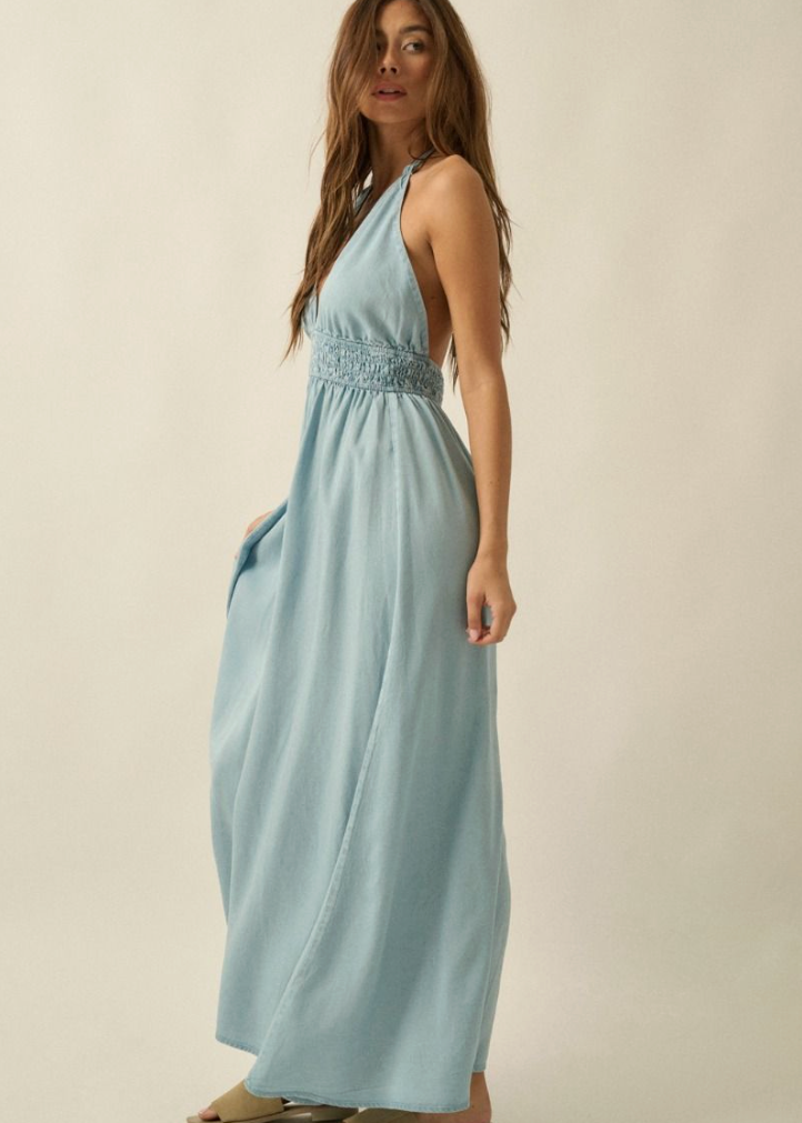 Woman wearing a light blue dress against a beige background