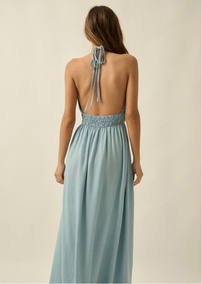Woman wearing a light blue dress with an open back on a beige background